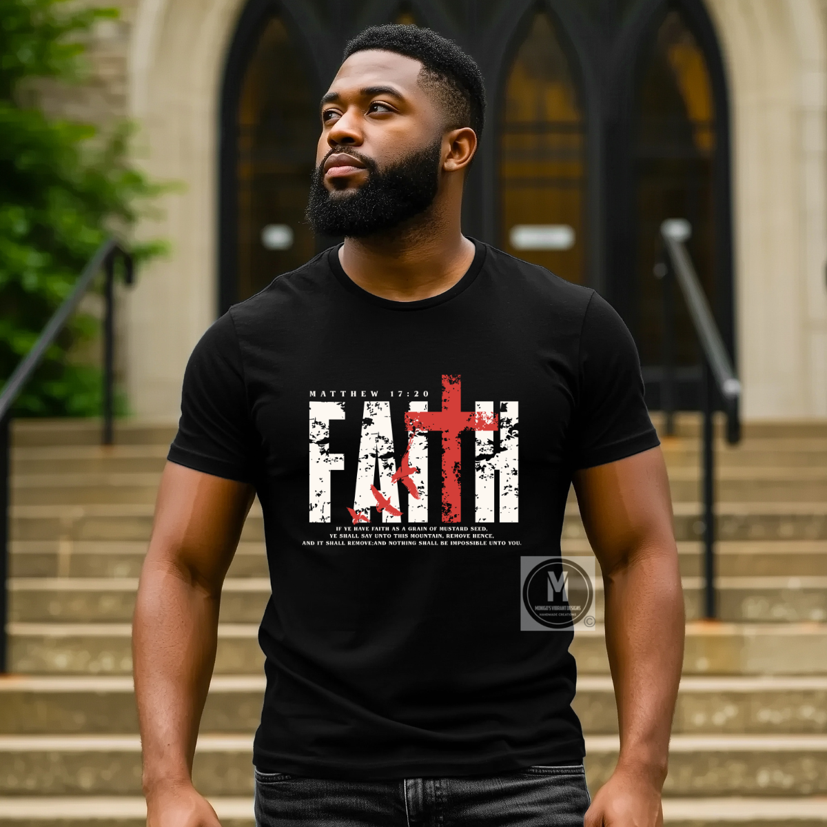 A man wearing a black graphic t-shirt with a distressed white 'FAITH' design and a red cross, standing in front of a stone building with arched windows.