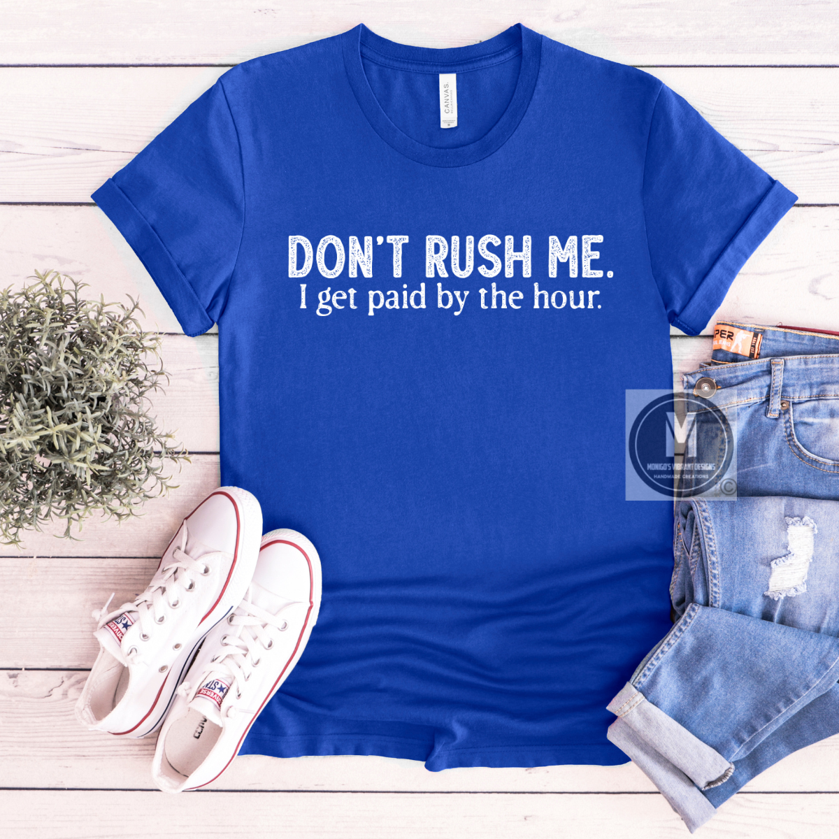 Bright blue t-shirt with the phrase "SOME BODY GOTTA DO IT." by Kendrick Lamar, paired with distressed jeans and white sneakers.
