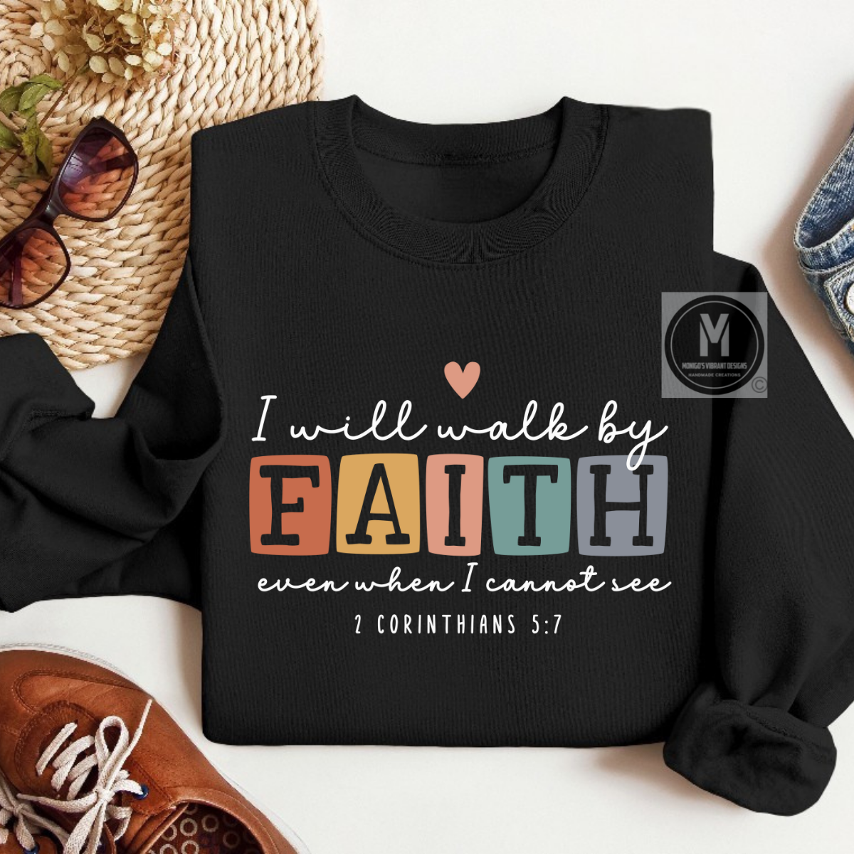Black sweatshirt with motivational quote on a white surface with accessories.