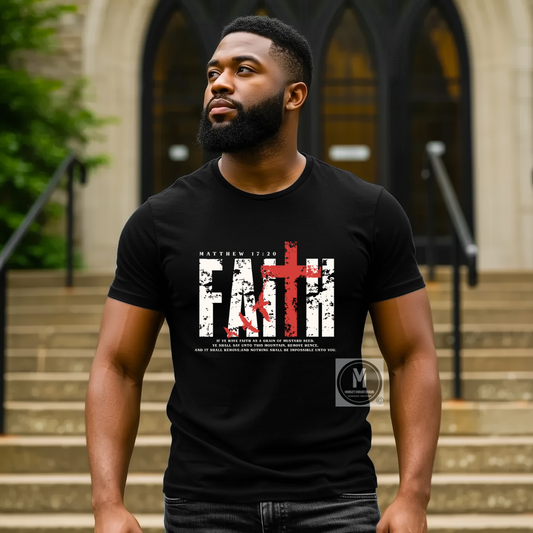 A man wearing a black graphic t-shirt with a distressed white 'FAITH' design and a red cross, standing in front of a stone building with arched windows.