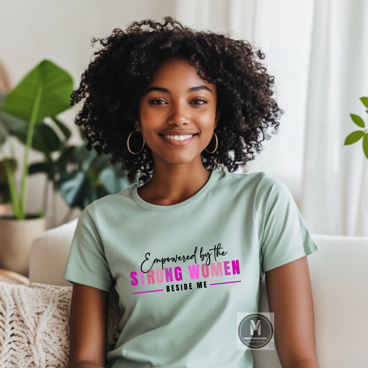 Woman wearing a light green t-shirt with a motivational quote, sitting in a cozy room with plants.