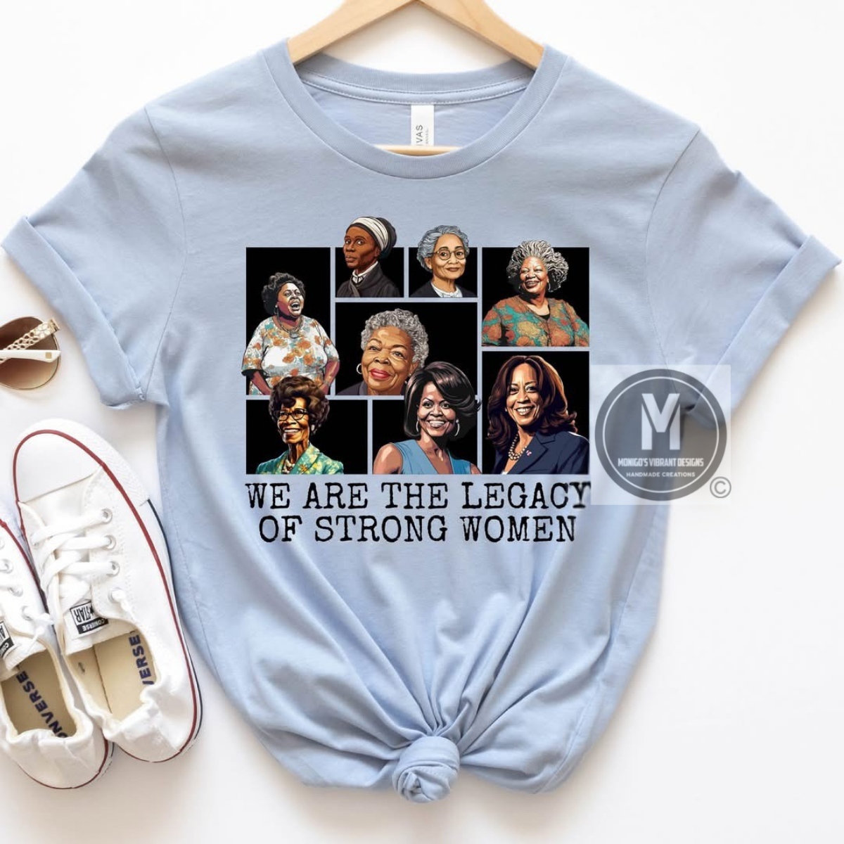 Light blue t-shirt with graphic of women and text 'We are the legacy of strong women' on a white background.