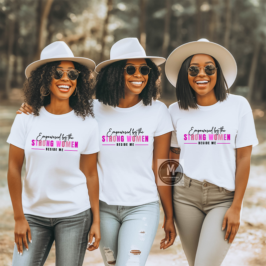 Three women wearing white t-shirts with a motivational quote, standing outdoors.